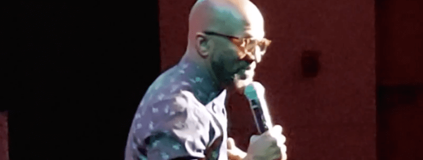 Man holding microphone on stage, performing.